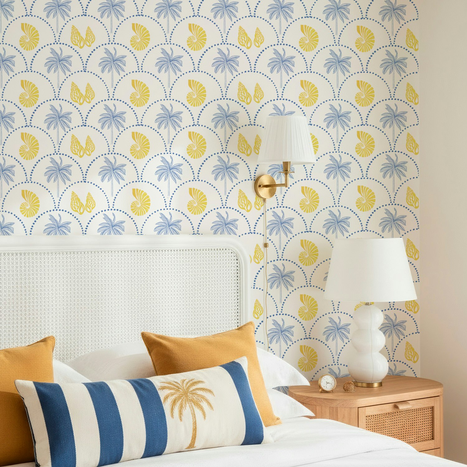 Papel de Parede Mediterrâneo Estilo Praia Chic  com palmeiras na cor azul e conchas em quarto com cabeceira branca e mesa de cabeceira amadeirada